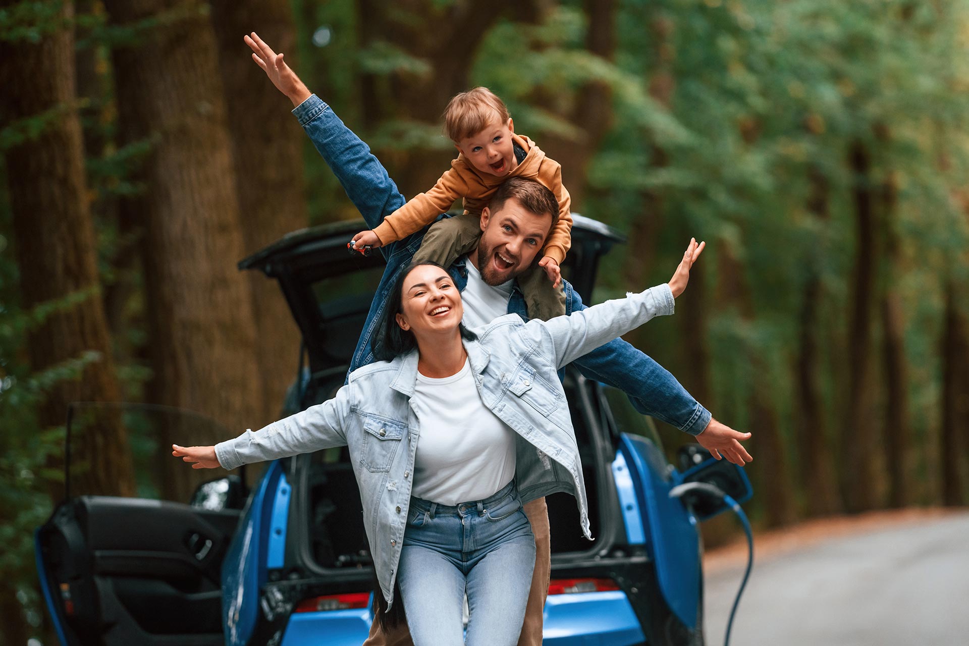 Família sorridente ao lado do carro, representando segurança e proteção veicular