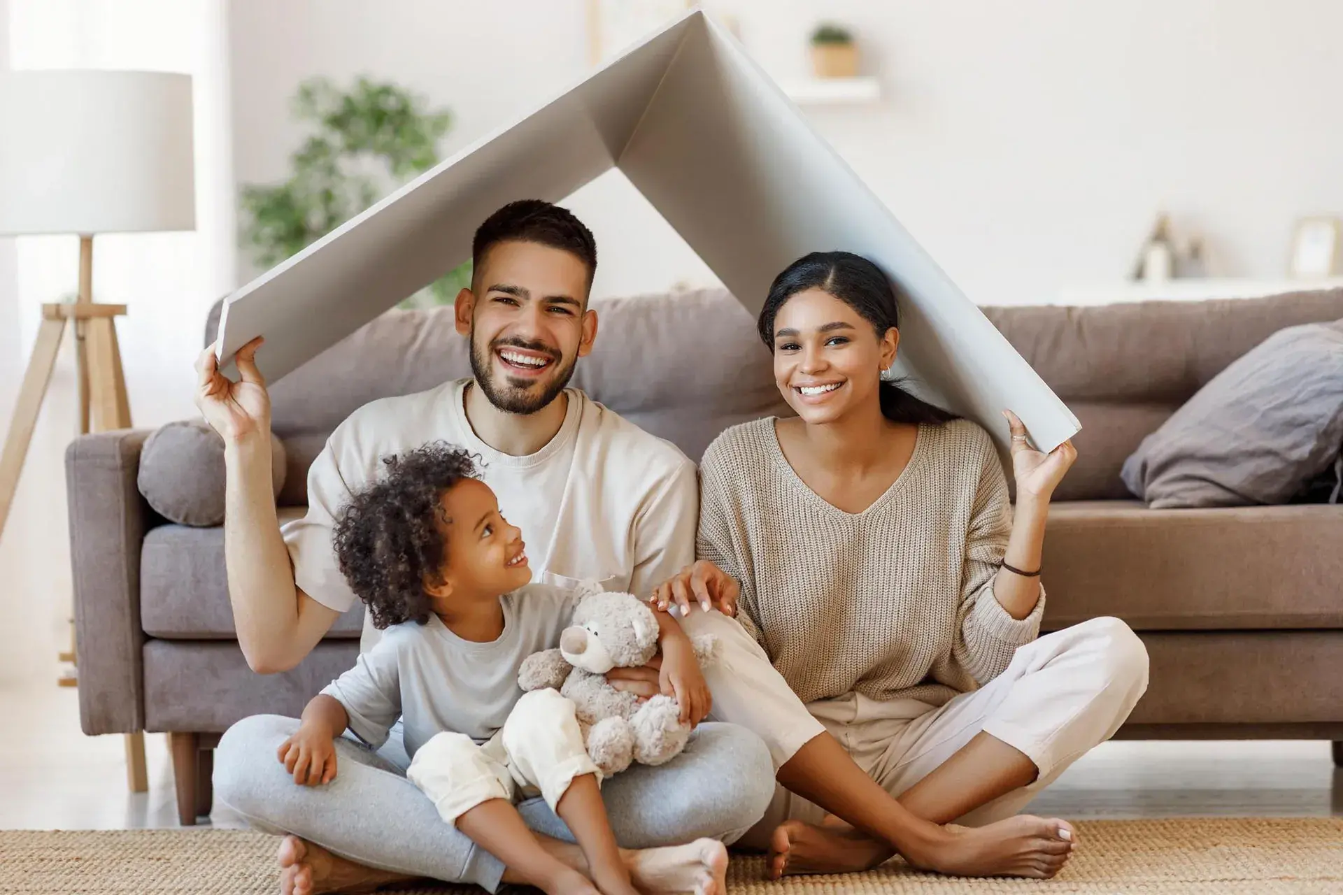 Família reunida e sorrindo em casa, representando segurança e acolhimento